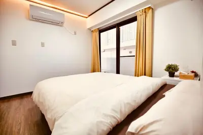 a bedroom with two beds and a window at Alice\u5c0f\u5c4b601 in Tokyo