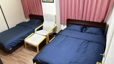 a bedroom with two beds and a chair at Alice\u5c0f\u5c4b601 in Tokyo