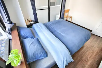 a bed with blue sheets and pillows in a room at Alice\u5c0f\u5c4b601 in Tokyo