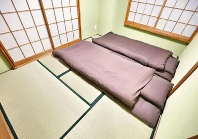 a small bed in a corner of a room at Alice 501 in Tokyo