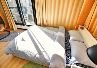a bed sitting in a room with a window at Alice 501 in Tokyo