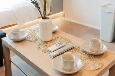 a coffee table with three cups and a vase on it at saiei hotel 301 in Tokyo