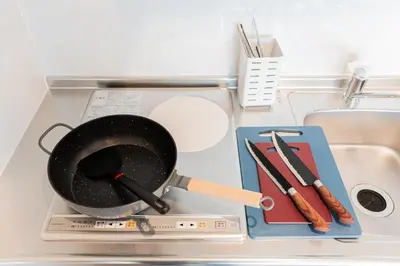 a frying pan and utensils on top of a stove at saiei hotel 301 in Tokyo