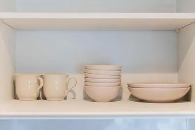 a shelf with three cups and bowls on it at saiei hotel 301 in Tokyo