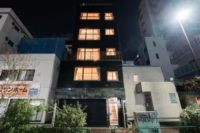 a tall building with many windows at night at saiei hotel 301 in Tokyo