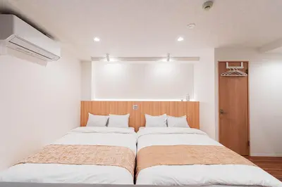 a bedroom with two beds and a window at saiei hotel 302 in Tokyo