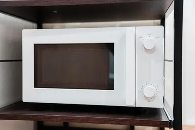 a white microwave oven sitting on a shelf at saiei hotel 302 in Tokyo