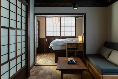 a room with a bed and a table and a mirror at Hotel Suzumeya Tsukiji plus kitchen in Tokyo