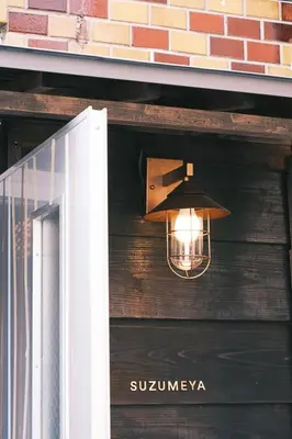 a light hanging from the side of a building at Hotel Suzumeya Tsukiji plus kitchen in Tokyo