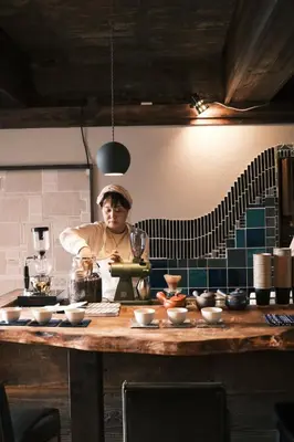 a woman standing in a kitchen preparing food at Hotel Suzumeya Tsukiji plus kitchen in Tokyo