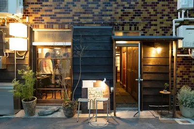 a storefront with two stools in front of a building at Hotel Suzumeya Tsukiji plus kitchen in Tokyo