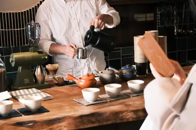 a man standing in a kitchen preparing food at Hotel Suzumeya Tsukiji plus kitchen in Tokyo