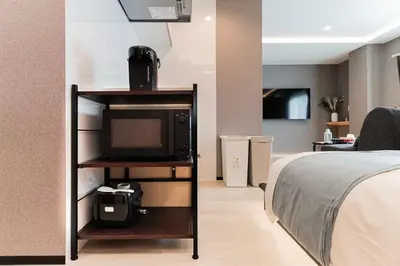 a bedroom with a bed and a television on a shelf at saiei hotel 402 in Tokyo