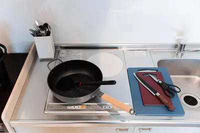 a frying pan on top of a stove with tools at saiei hotel 402 in Tokyo