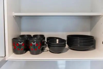 a row of black bowls and plates on a shelf at saiei hotel 402 in Tokyo
