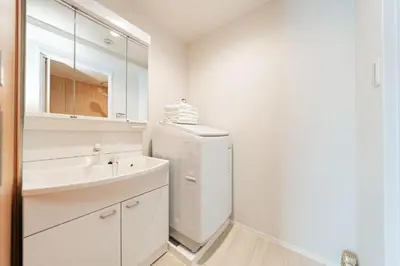 a white bathroom with a sink and a refrigerator at saiei hotel 402 in Tokyo