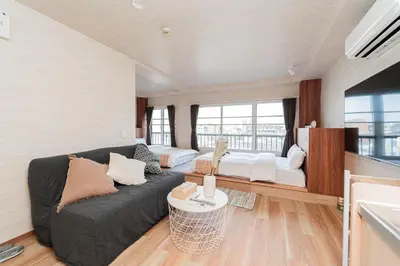 a living room with a couch and a large window at saiei hotel 501 in Tokyo