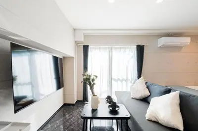 a living room with a blue couch and a tv at saiei hotel 502 in Tokyo
