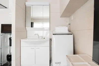 a small kitchen with white cabinets and a sink at saiei hotel 502 in Tokyo