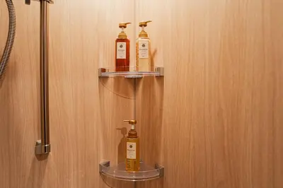 three bottles of soap are on shelves on a bathroom door at saiei hotel 502 in Tokyo
