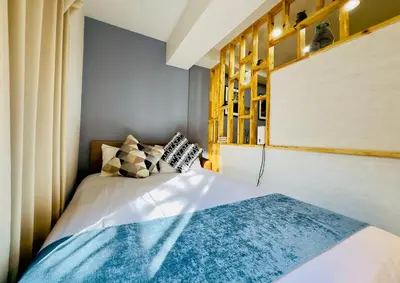 a bedroom with a bed with a blue rug on it at Yochomachi Hostel\u82e5\u677eSJ0357 in Tokyo