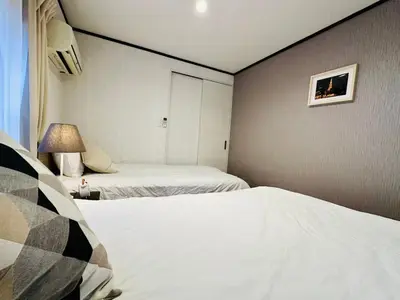 a hotel room with two beds and a lamp at Yochomachi Hostel\u82e5\u677eSJ0357 in Tokyo