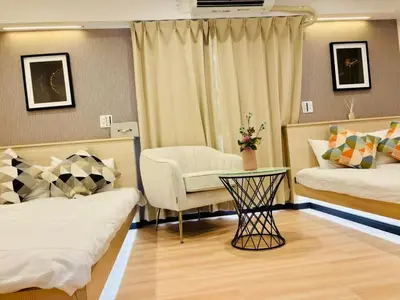 a hotel room with two beds and a chair at Yochomachi Hostel\u82e5\u677eSJ0357 in Tokyo