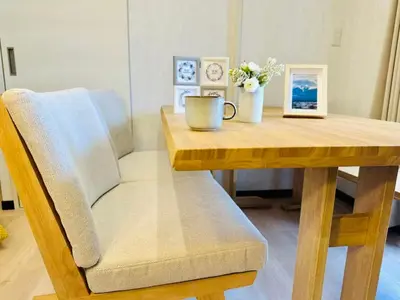a wooden table with a chair and a coffee cup on it at Yochomachi Hostel\u82e5\u677eSJ0357 in Tokyo