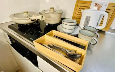 a kitchen counter with a stove with a tray of utensils at Yochomachi Hostel\u82e5\u677eSJ0357 in Tokyo