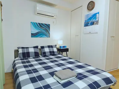 a bedroom with a blue and white checkered bed at #201WZNET\u6885\u5c4b\u6577\u99c52\u5206\u6a2a\u6d5c\u7fbd\u7530\u7a7a\u6e2f\u90fd\u5fc3\u4fbf\u5229\u5546\u5e97\u88571k\u9759\u304b\u306a\u753a in Tokyo
