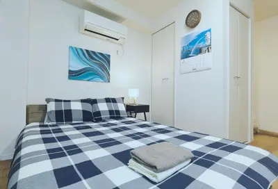 a bedroom with a blue and white checkered bed at #201WZNET\u6885\u5c4b\u6577\u99c52\u5206\u6a2a\u6d5c\u7fbd\u7530\u7a7a\u6e2f\u90fd\u5fc3\u4fbf\u5229\u5546\u5e97\u88571k\u9759\u304b\u306a\u753a in Tokyo