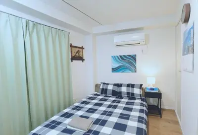 a bedroom with a bed with a checkered blanket at #201WZNET\u6885\u5c4b\u6577\u99c52\u5206\u6a2a\u6d5c\u7fbd\u7530\u7a7a\u6e2f\u90fd\u5fc3\u4fbf\u5229\u5546\u5e97\u88571k\u9759\u304b\u306a\u753a in Tokyo