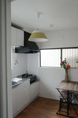 a kitchen with white cabinets and a wooden table at Oji House-KI0022 in Tokyo