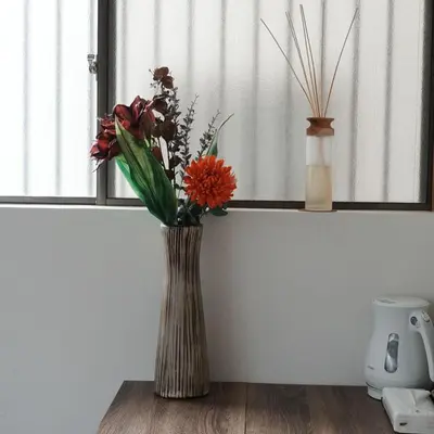 a vase with flowers in it sitting on a table at Oji House-KI0022 in Tokyo