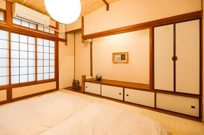 a bedroom with a large bed and windows at 5 minutes on foot from tokyo Asakusa Station!A beautiful house that has been fully renovated in 2024 for one group per day\u6771\u4eac\u96f7\u9580\u304b\u3089\u5f92\u6b694\u52061\u65e51\u7d44\u9650\u5b9a\u8cb8\u52072024\u5e74\u5168\u9762\u30ea\u30d5\u30a9\u30fc\u30e0\u6e08\u307f\u306e\u7dba\u9e97\u306a\u4e00\u8ed2\u5bb6 in Tokyo