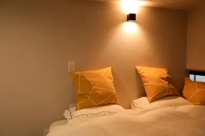 a bedroom with a bed with two pillows on it at 5 minutes on foot from tokyo Asakusa Station!A beautiful house that has been fully renovated in 2024 for one group per day\u6771\u4eac\u96f7\u9580\u304b\u3089\u5f92\u6b694\u52061\u65e51\u7d44\u9650\u5b9a\u8cb8\u52072024\u5e74\u5168\u9762\u30ea\u30d5\u30a9\u30fc\u30e0\u6e08\u307f\u306e\u7dba\u9e97\u306a\u4e00\u8ed2\u5bb6 in Tokyo