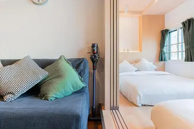a bedroom with a blue couch with pillows and a mirror at saiei hotel 201 in Tokyo