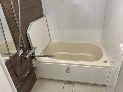a small white tub in a bathroom with a shower at saiei hotel 201 in Tokyo