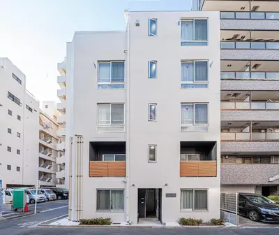 an apartment building with a white facade at Float Inn Shin-Okachimachi in Tokyo