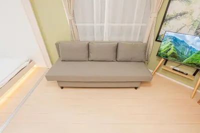 a couch in a living room with a window at Float Inn Shin-Okachimachi in Tokyo