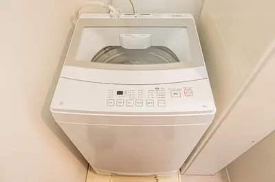 a washing machine in the corner of a room at Float Inn Shin-Okachimachi in Tokyo