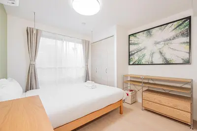 a bedroom with a bed and a tv on the wall at Float Inn Shin-Okachimachi in Tokyo