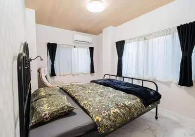 a bedroom with a bed in a room with windows at Kasai Light Luxury House 101 in Tokyo