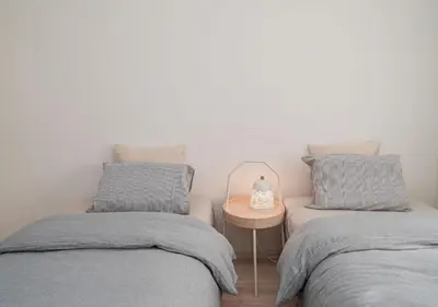two twin beds in a room with a side table at Kasai Light Luxury Hotel 201 in Tokyo