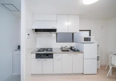 a white kitchen with a sink and a refrigerator at Kasai Light Luxury Hotel 201 in Tokyo