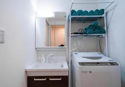 a small bathroom with a sink and a washing machine at Kasai Light Luxury Hotel 201 in Tokyo