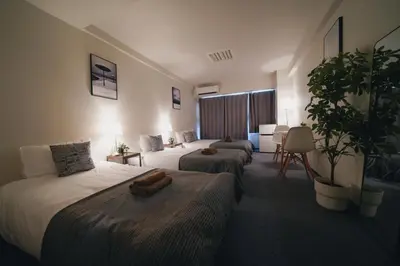 a hotel room with two beds and a couch at 4 minutes walk from Shibuya Station 3 beds in Tokyo