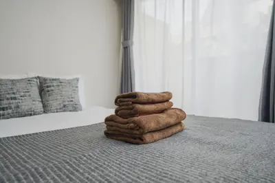 a stack of towels sitting on top of a bed at 4 minutes walk from Shibuya Station 3 beds in Tokyo