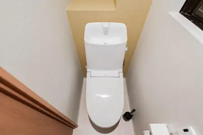 a white toilet in a corner of a bathroom at saiei hotel 202 in Tokyo