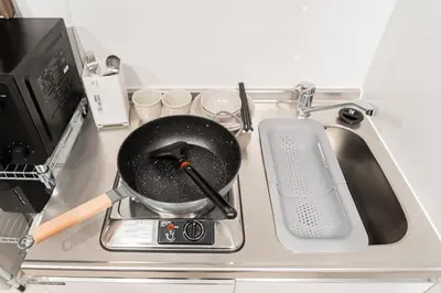 a pan sitting on top of a stove next to a sink at saiei hotel 202 in Tokyo